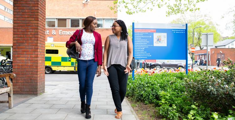 Two people walking outside A&E