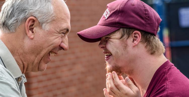 Two men smiling at each other