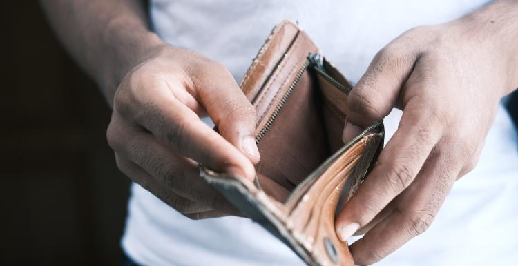 Man opening empty brown wallet