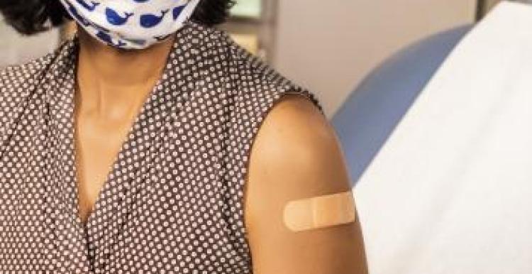 Woman wearing a mask receiving a vaccination