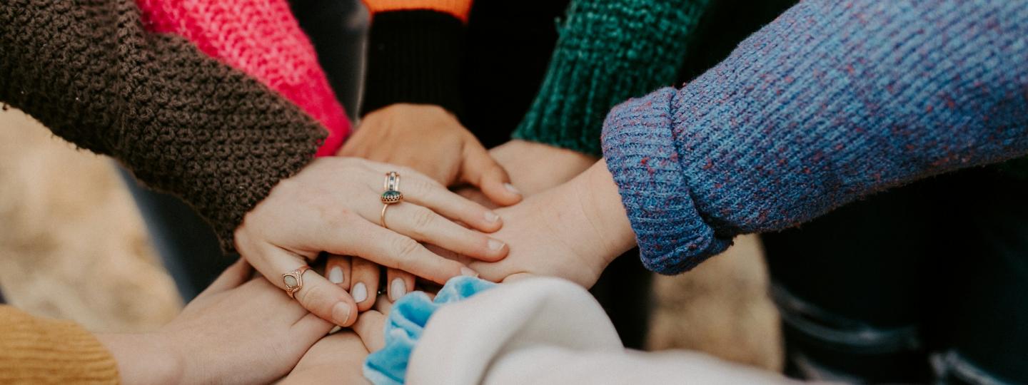 Hands together in middle of a circle