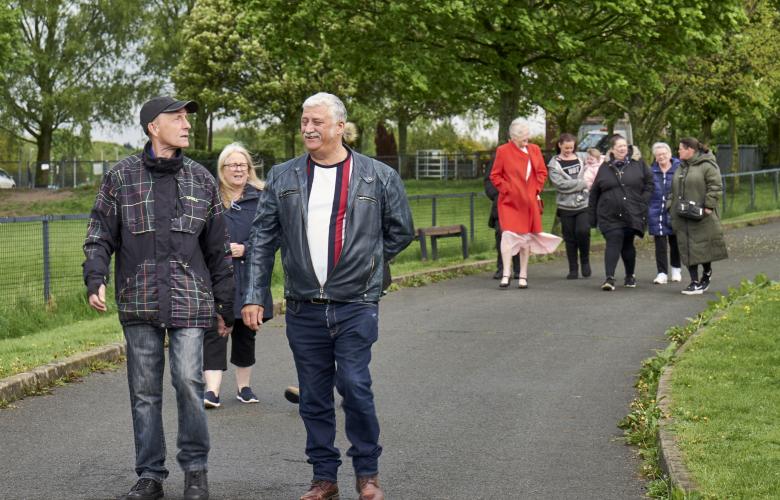 Group of people walking in a park range of ages and nationalities